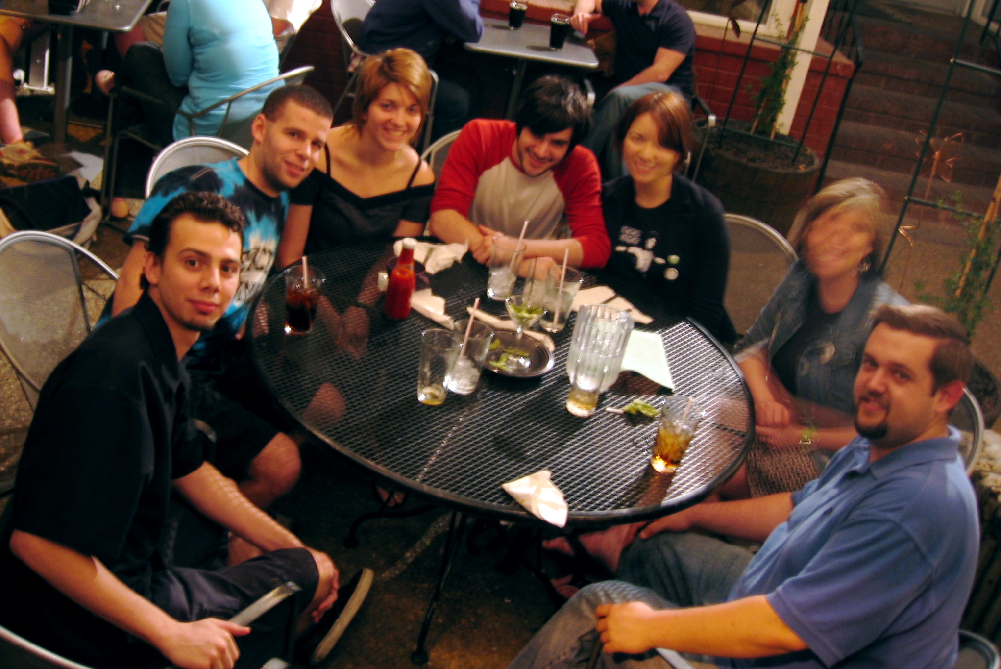 a bunch of friends are at a table with beers