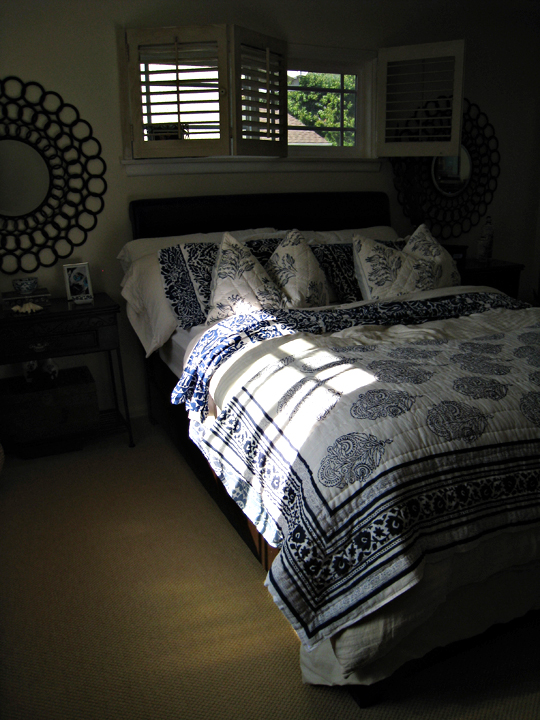 a large bed has an intricate patterned comforter and matching pillows