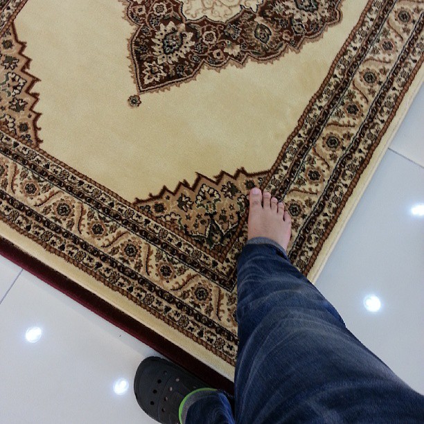 someone standing on the floor with their feet on the rug