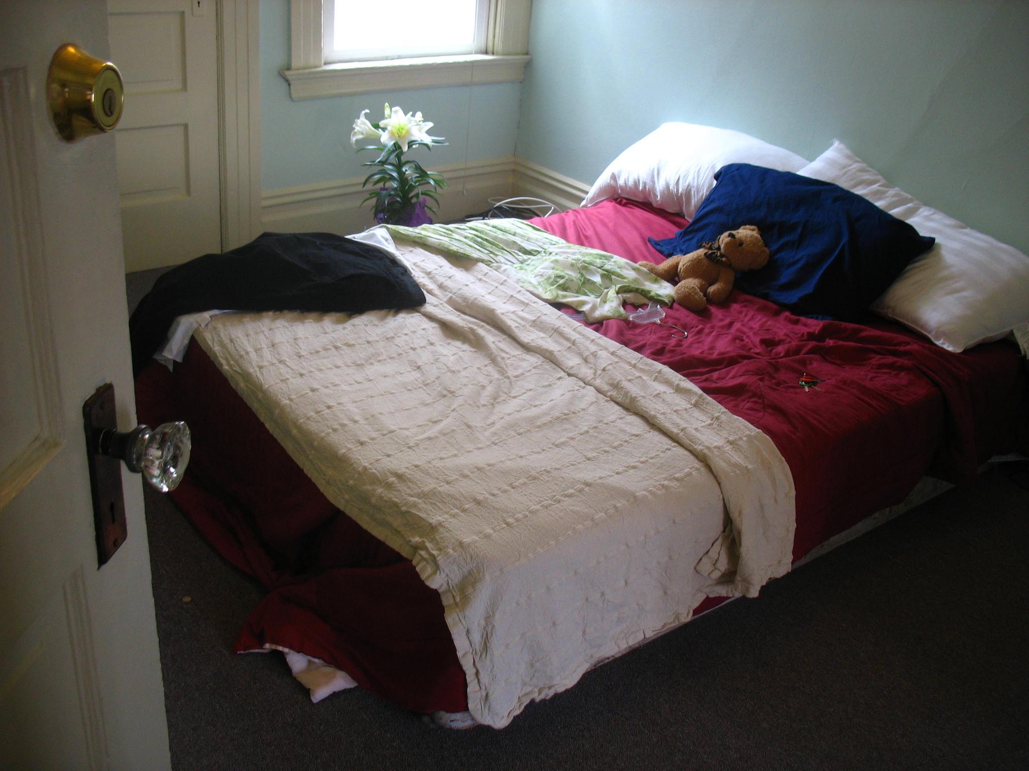 a bed with various blankets and stuffed animals