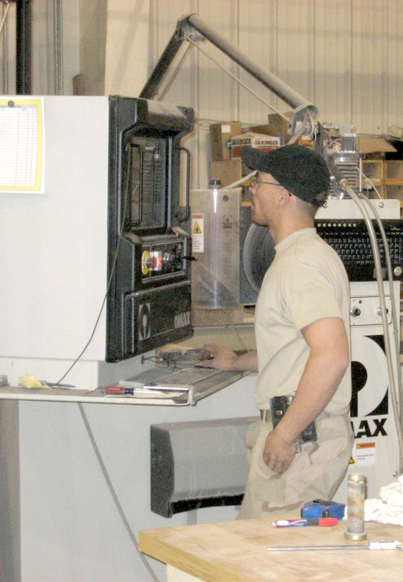 a man stands in a machine shop working on soing