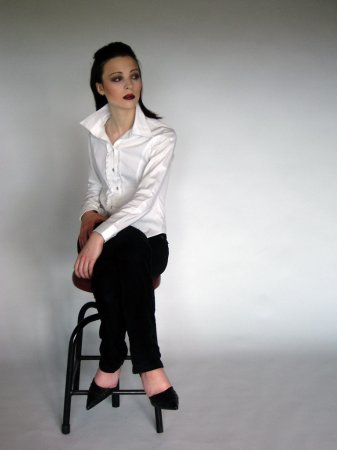 a  in heels sitting on a stool