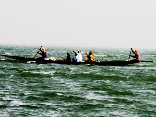 people in the ocean on a boat with two oars