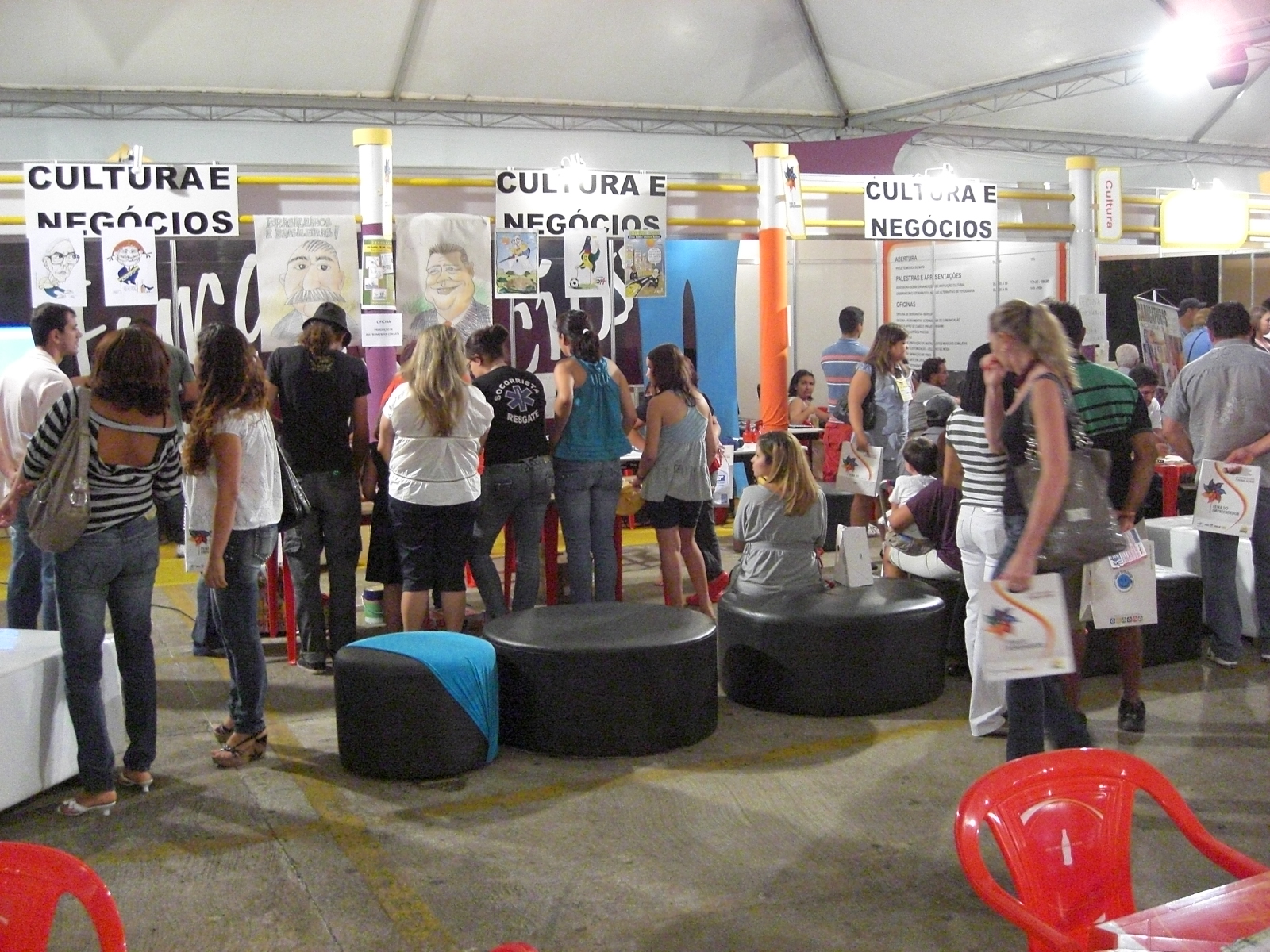 group of people looking at various items in an exhibit