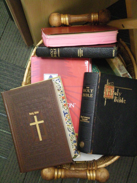 a basket holding a stack of bibles sitting on top of a floor
