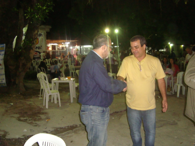 two men are having a conversation while standing in front of a bar