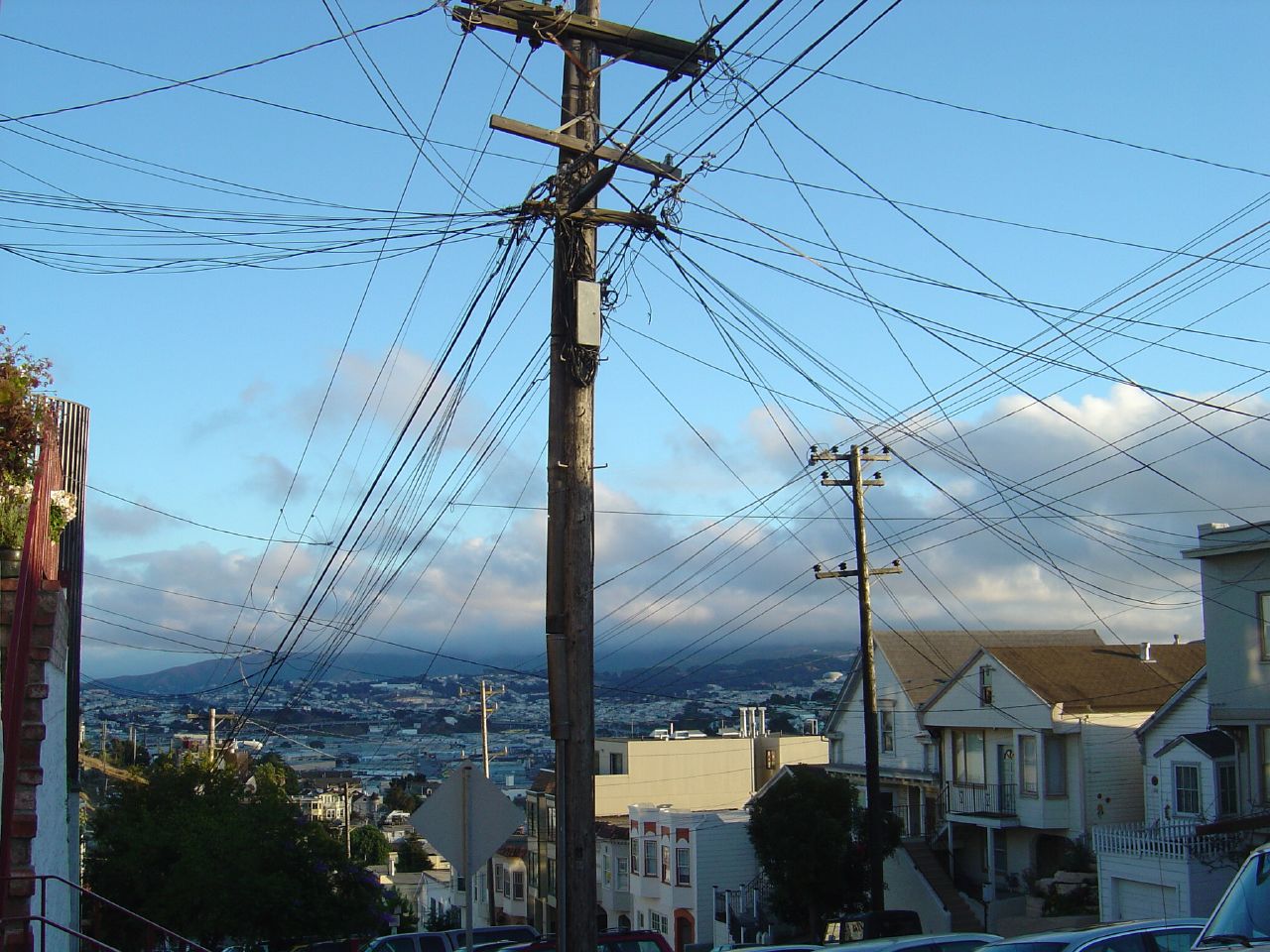 cars parked along side of a road lined with power lines