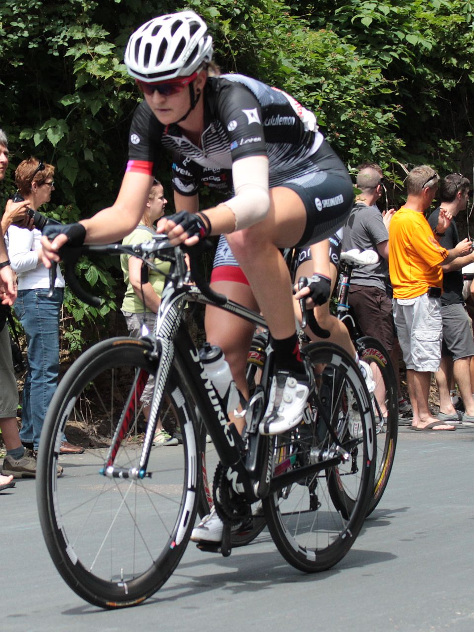 a young man is on his bicycle while some people watch