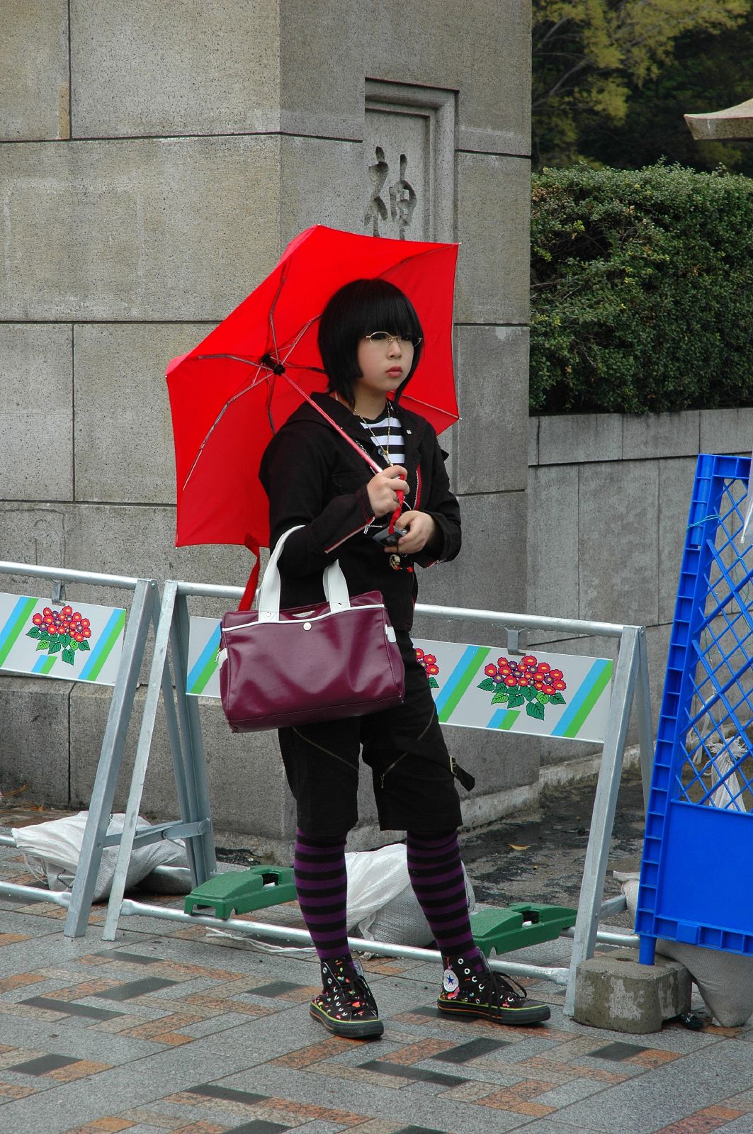 a girl on a sidewalk holding an umbrella