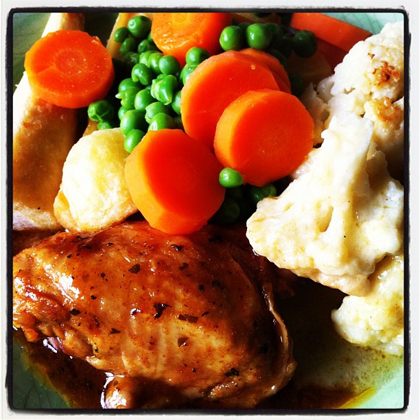 a plate with carrots, peas, and mashed potatoes