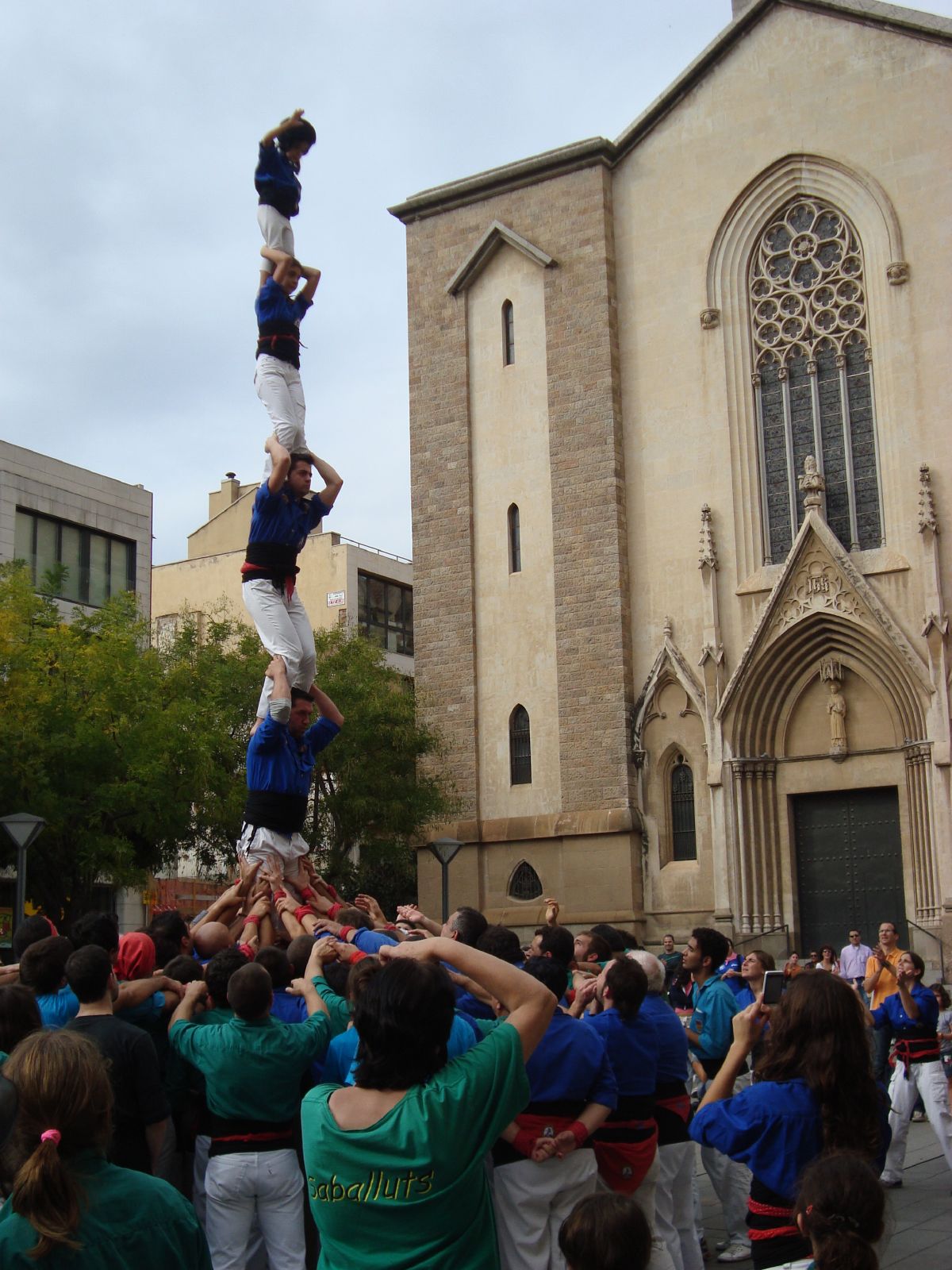 several people are doing aerial tricks in front of an old church