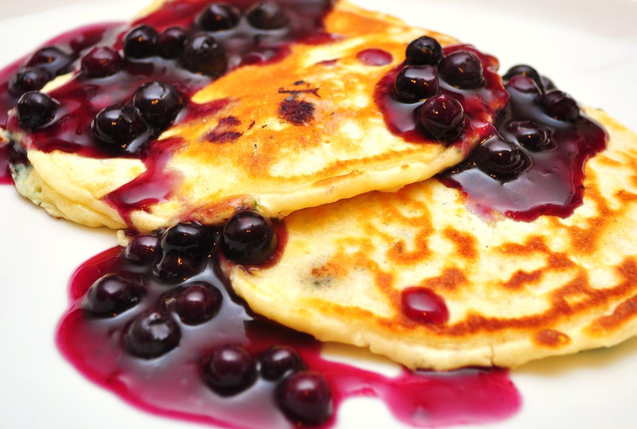 the two pancakes are topped with blue berries