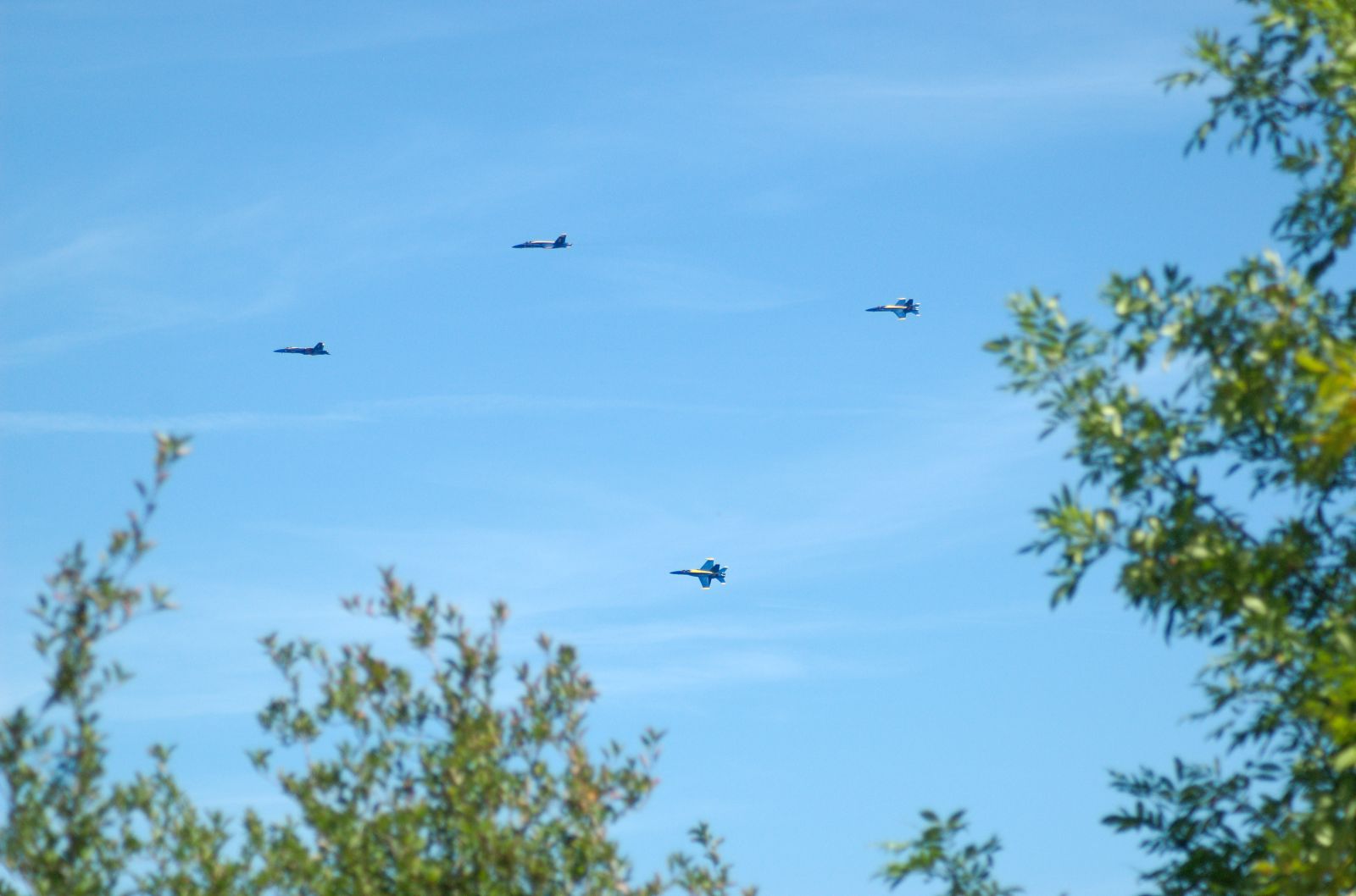 four planes are flying through the clear blue sky