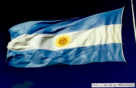 the flag of argentina flying in a blue sky