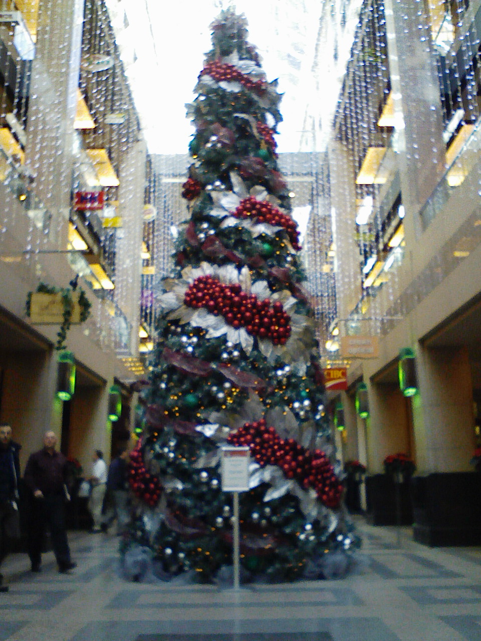 the christmas tree is covered with ornaments in a large building