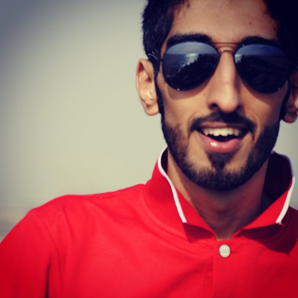 a close up of a person wearing a red shirt and sunglasses