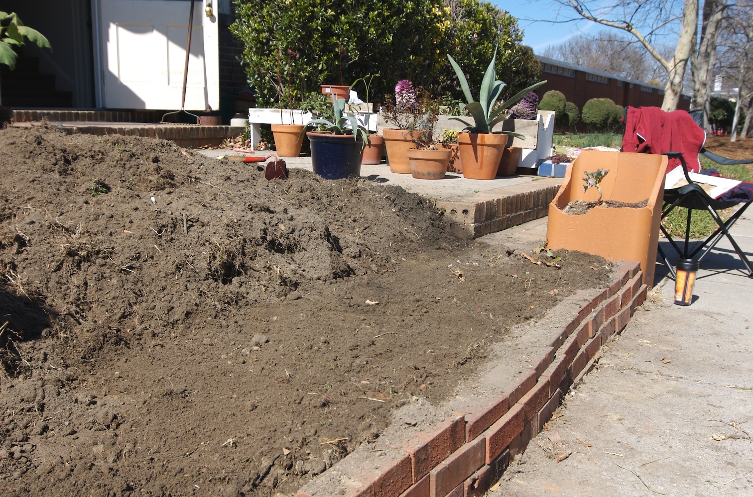 a patio and yard with a pile of dirt on the ground