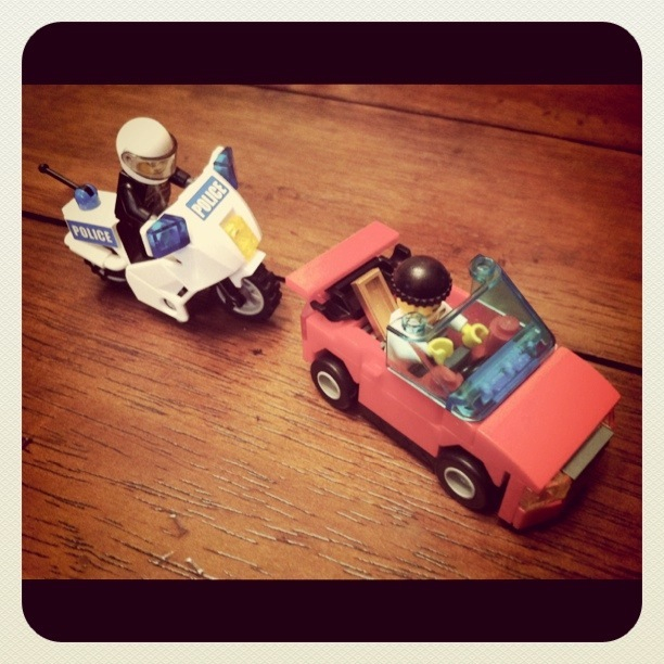 a cop motorcycle and toy car on a table