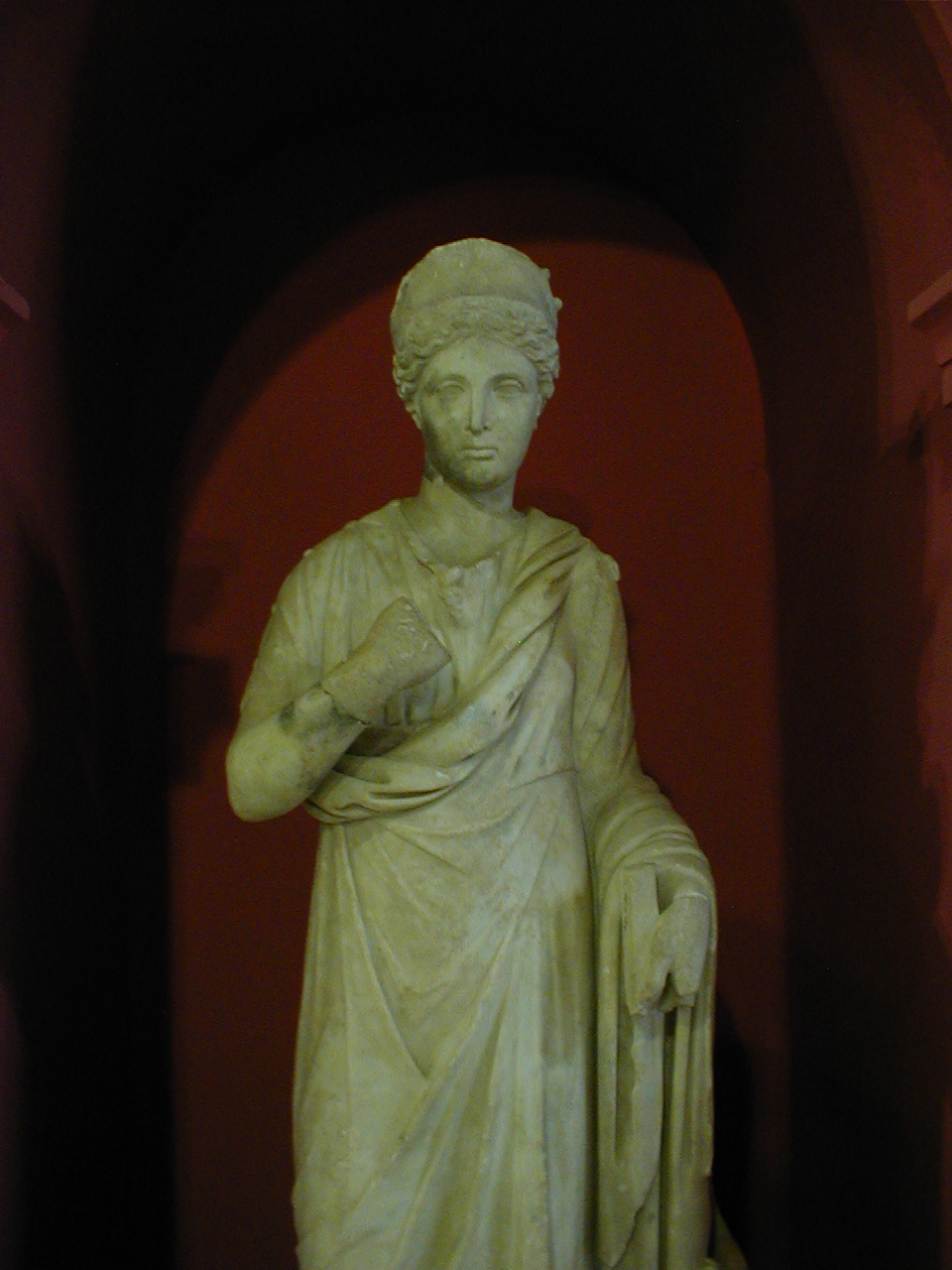 a statue in a red walled niche