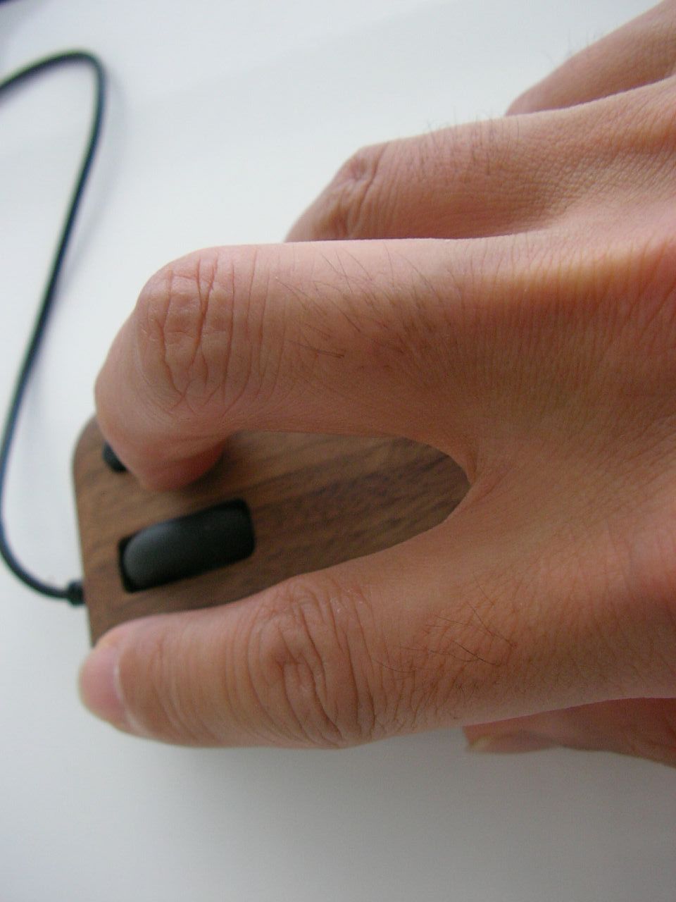 a hand holding a mouse in front of a mouse pad