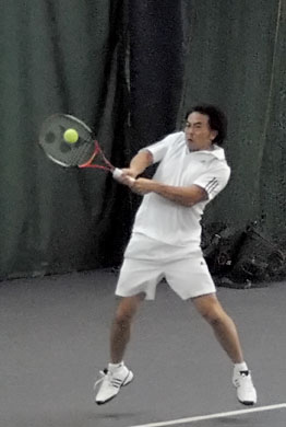 tennis player hitting ball with racket on the court