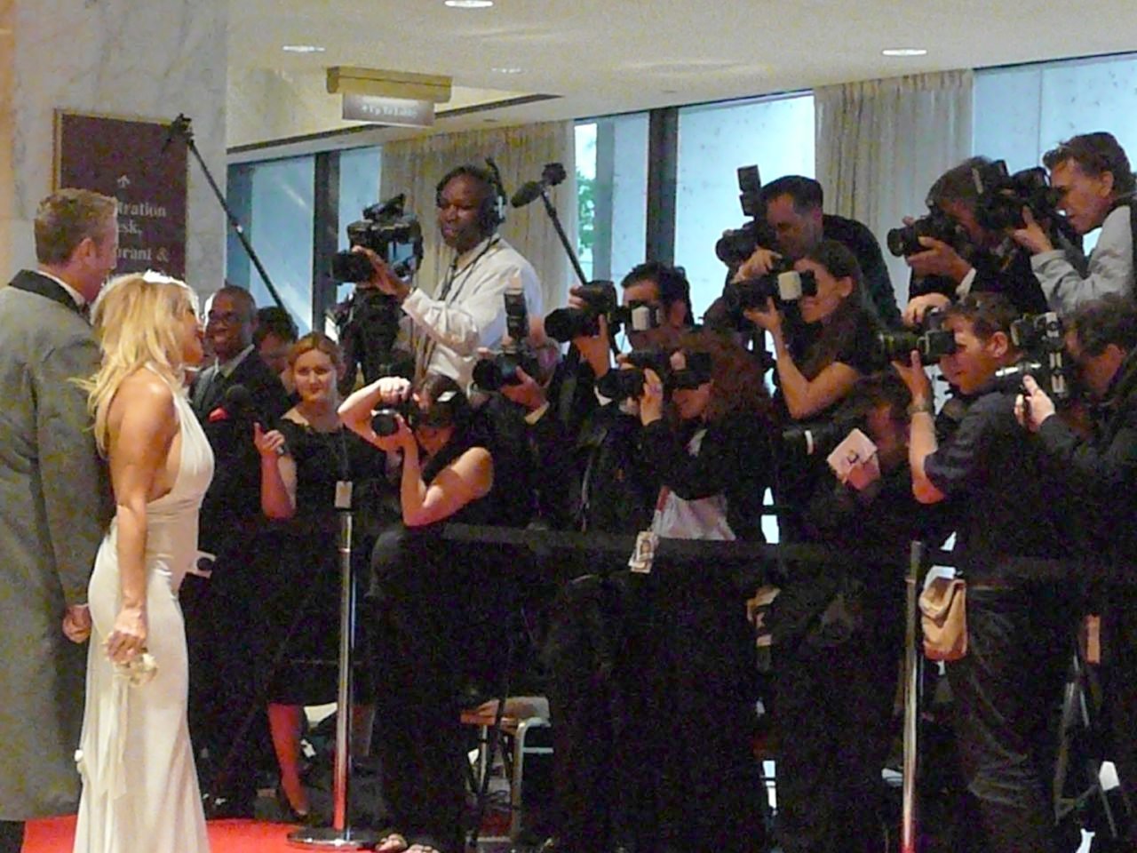 two women with cameras standing next to some people