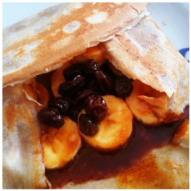 crepes with raisins, nuts and syrup on a plate