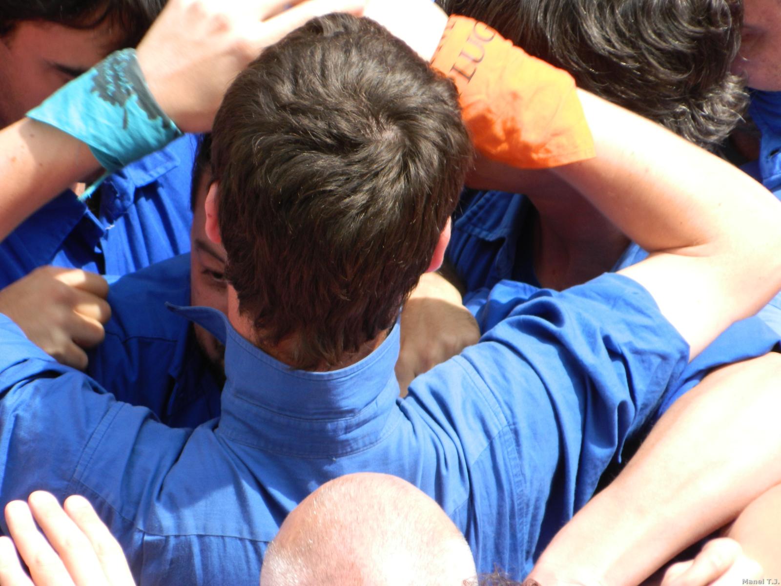 group of people wearing blue uniforms holding hands up