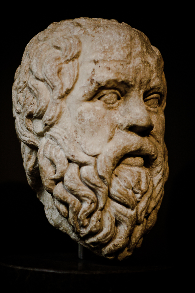 an ancient sculpture of a man with an odd look