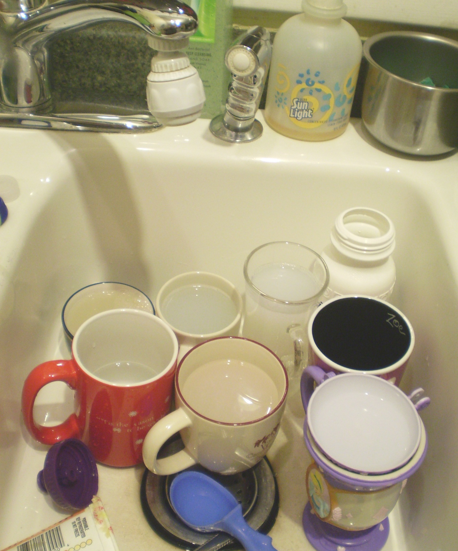 mugs and dishes are sitting in the bathroom sink