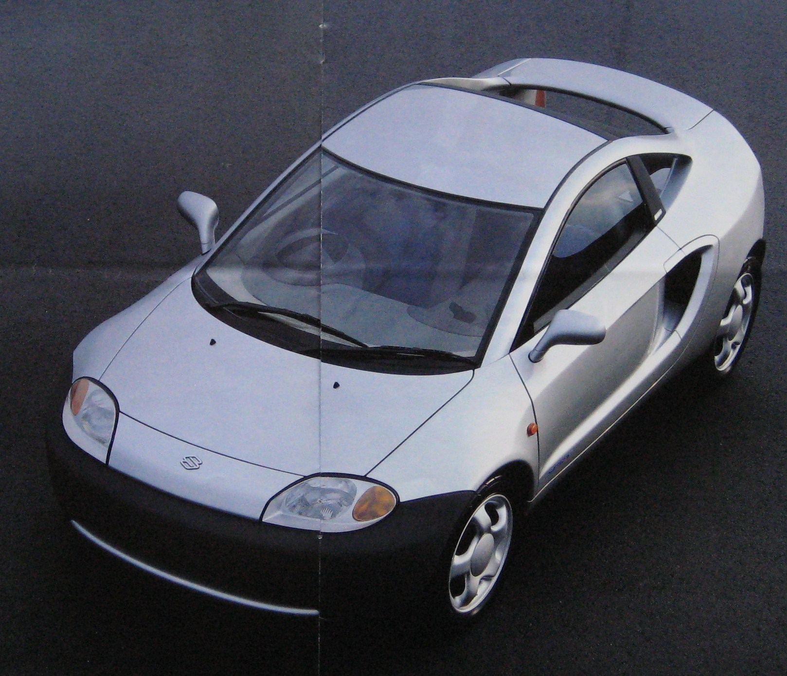 a small silver car is parked on the road