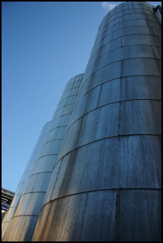 a large industrial grain storage tank against a blue sky