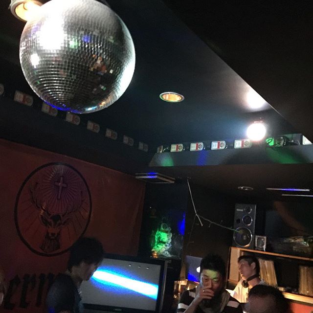 two mirror ball hanging from the ceiling above a group of people