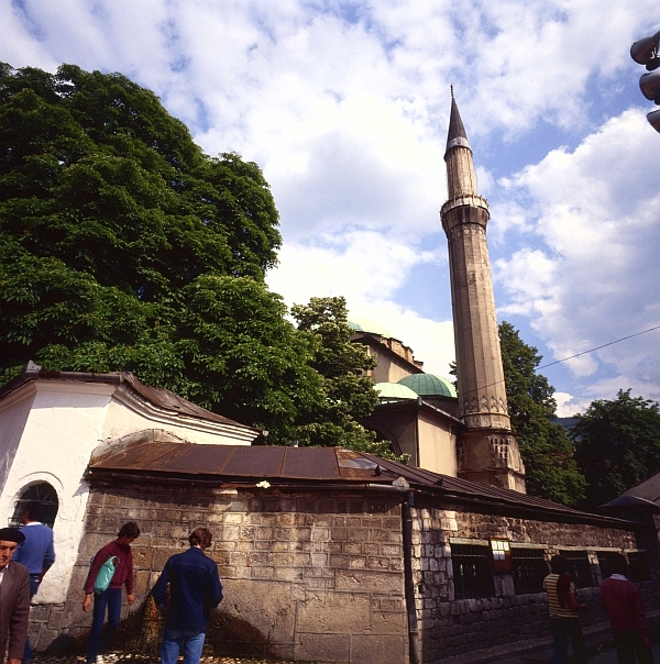 several people in the street near a mosque