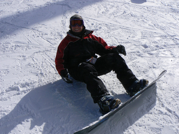 the snowboarder sitting down is wearing his gear