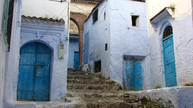 a staircase leads up to two buildings painted in blue