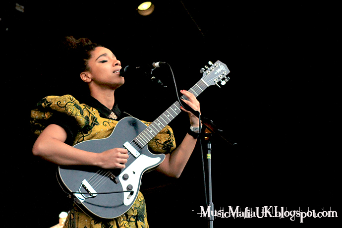 a woman playing a guitar with a microphone