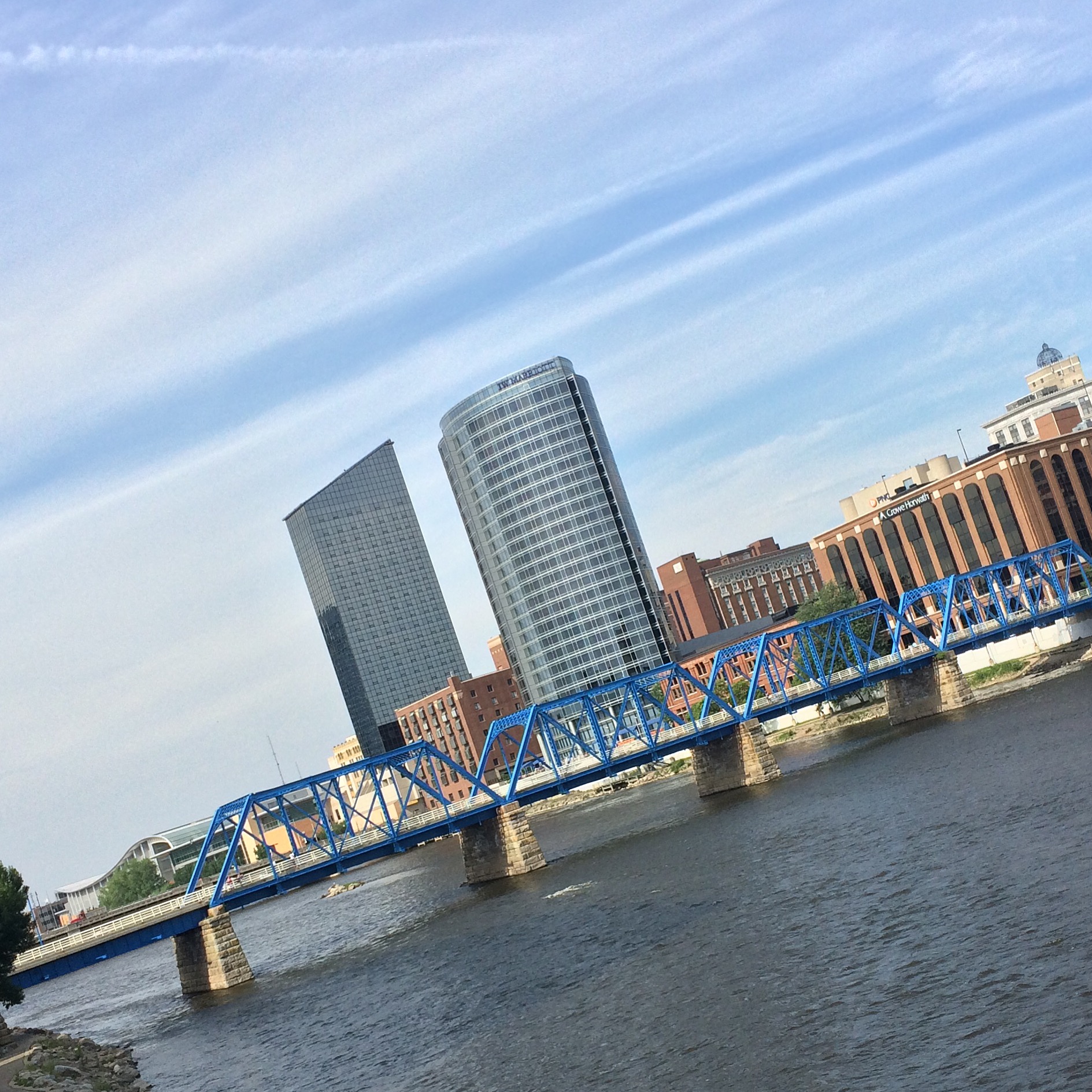 a very tall blue bridge over a river