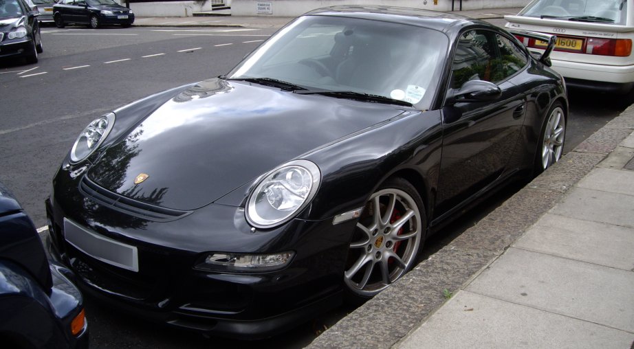 there is a black porsche parked at the curb