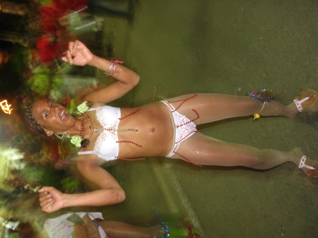 woman in bikini suit dancing on grass with people behind