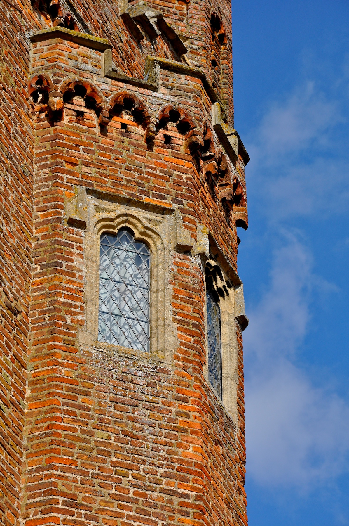 the large brick tower has two glass windows