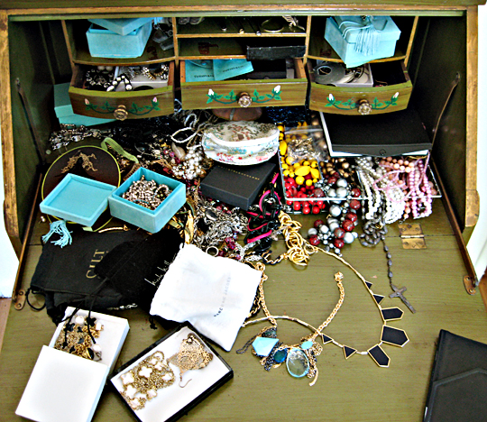 there is many pieces of jewelry displayed on a wooden surface