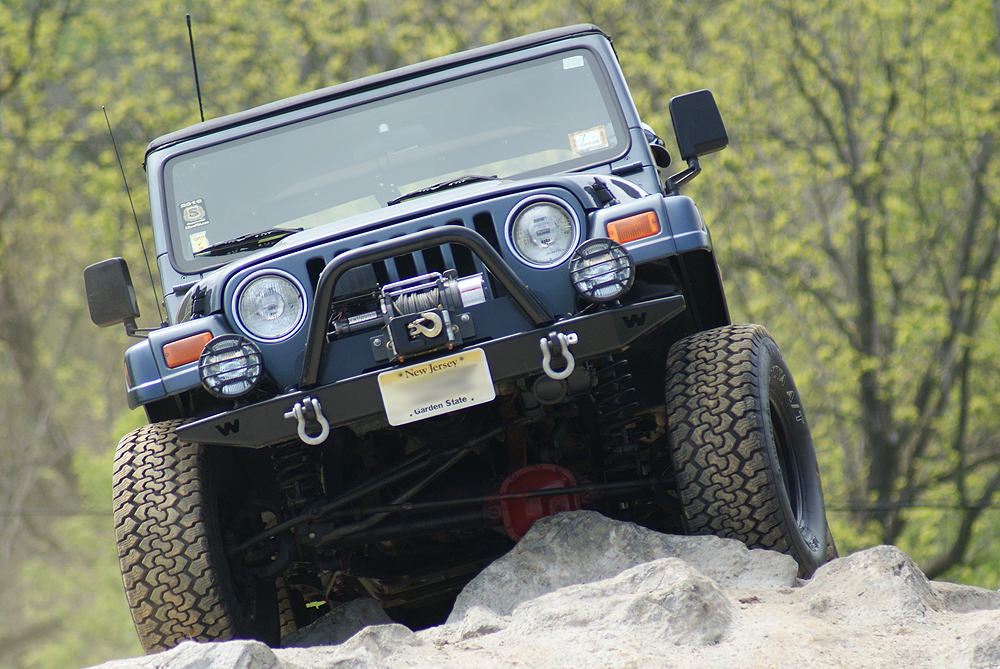 jeeps going around a very sharp turn on a rocky terrain