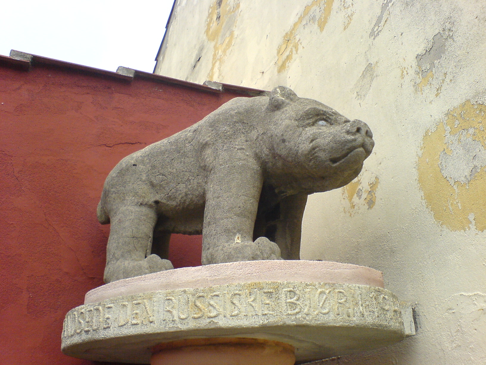 the sculpture is sitting on the side of the building