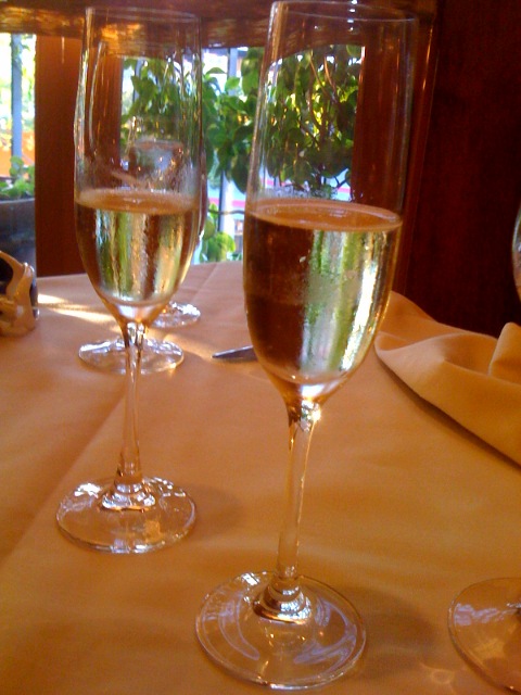 three glasses of wine and champagne sit on a table