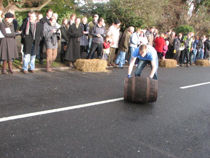 a man with a large log is trying to pull a large group of people away from the road