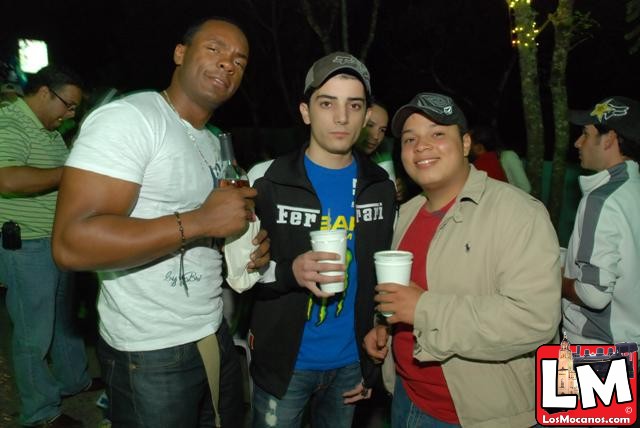 three young men holding drinks in a wooded area