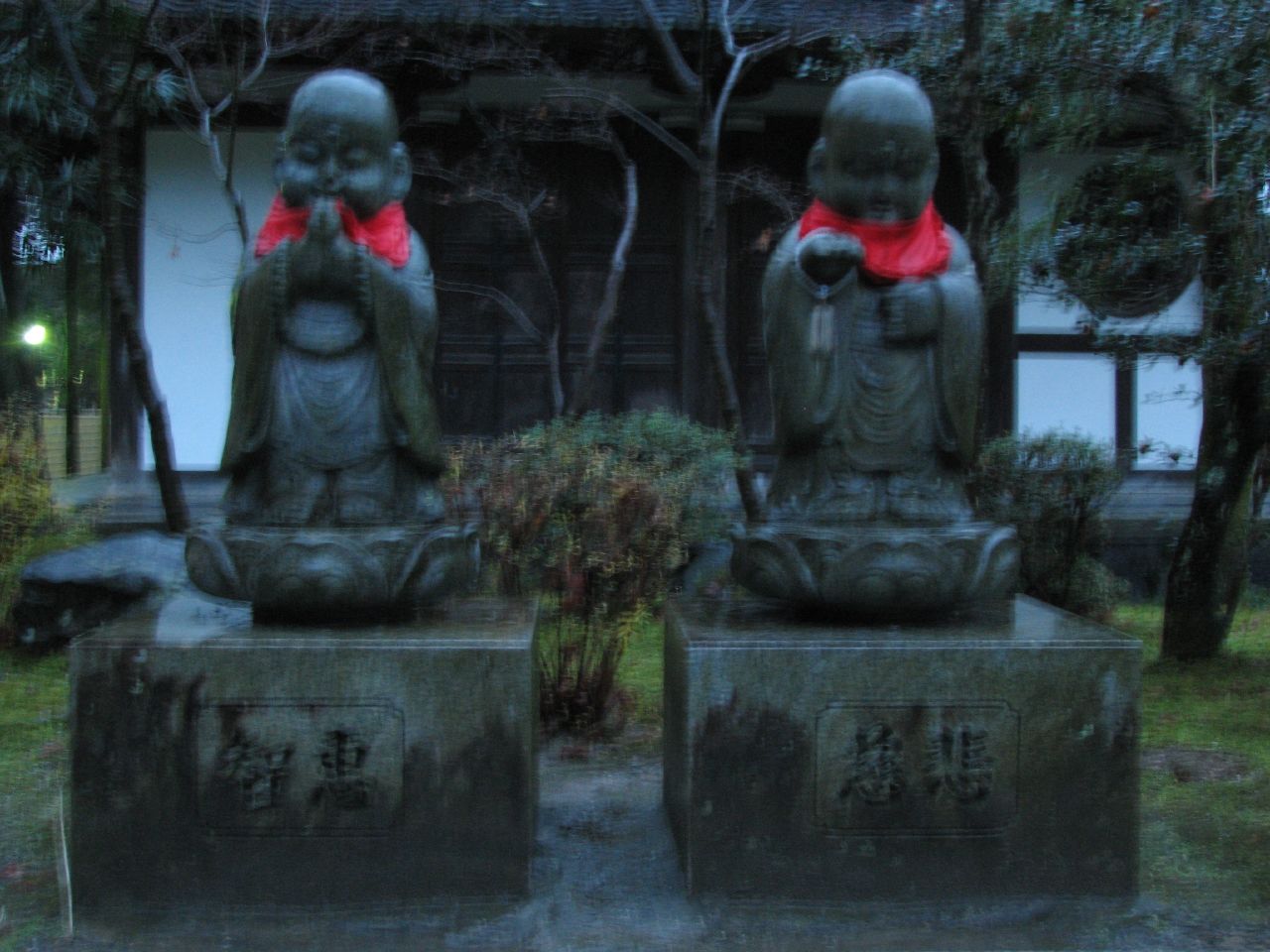 two small statues sitting on top of a bench