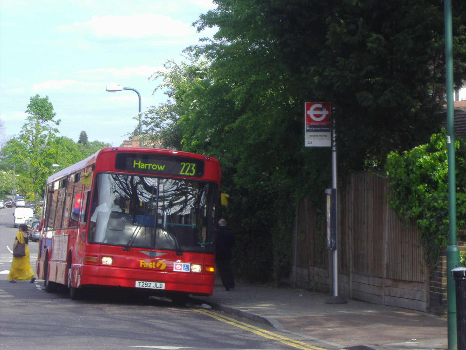 a red bus is stopped on the road for passengers