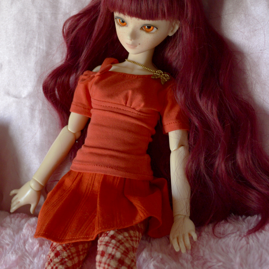 a doll with long red hair and bright orange eyes